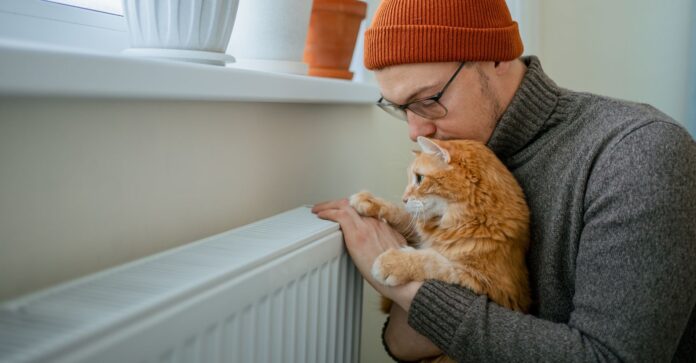 Young,Man,Wearing,A,Warm,Hat,And,Sweater,,Embracing,His